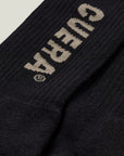 Model wearing Cuera 2-pack Cuera Padel Socks in Black/Sand, front studio view
