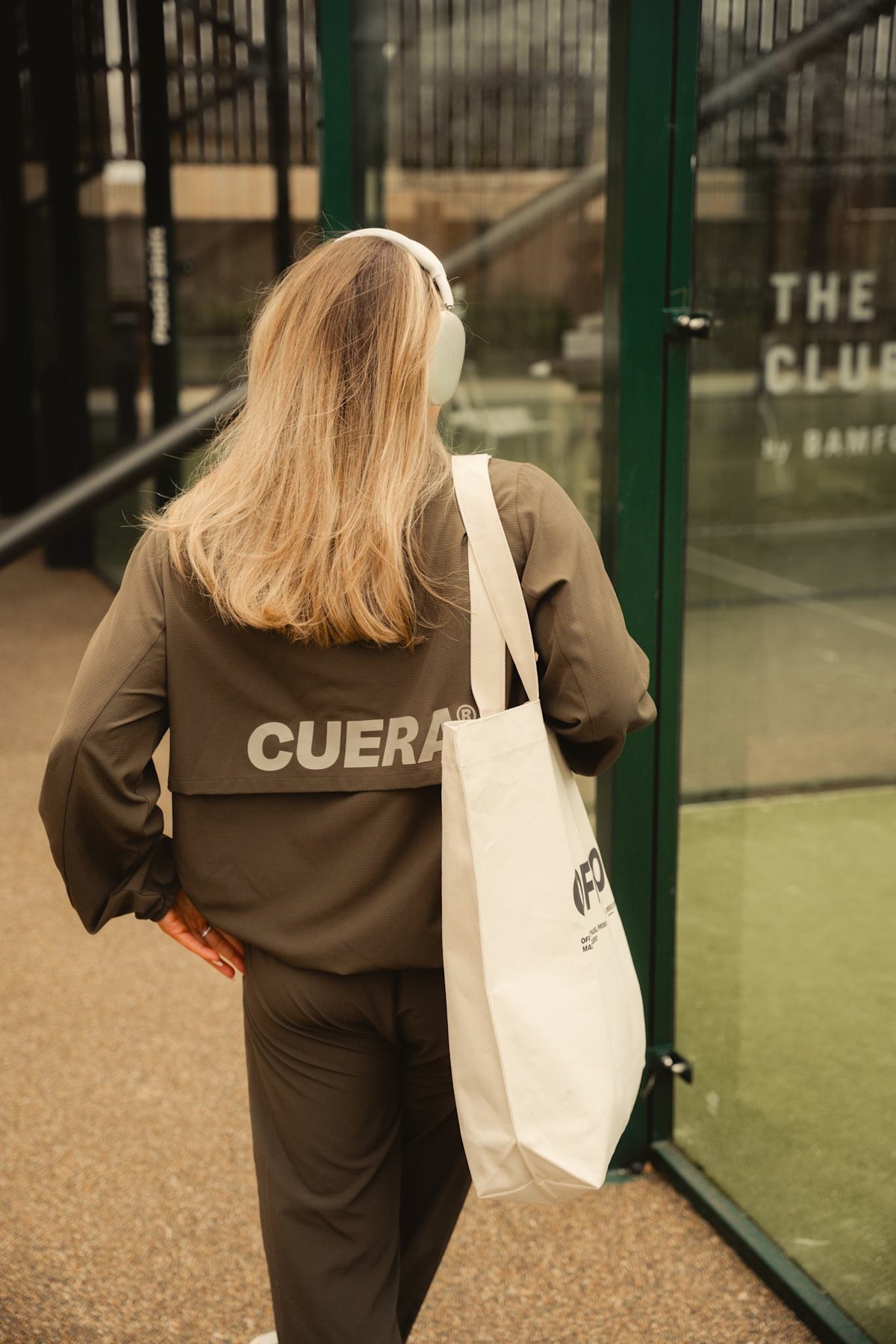Model wearing Cuera Active Cuera Track Jacket in Army, lifestyle action shot on the padel court